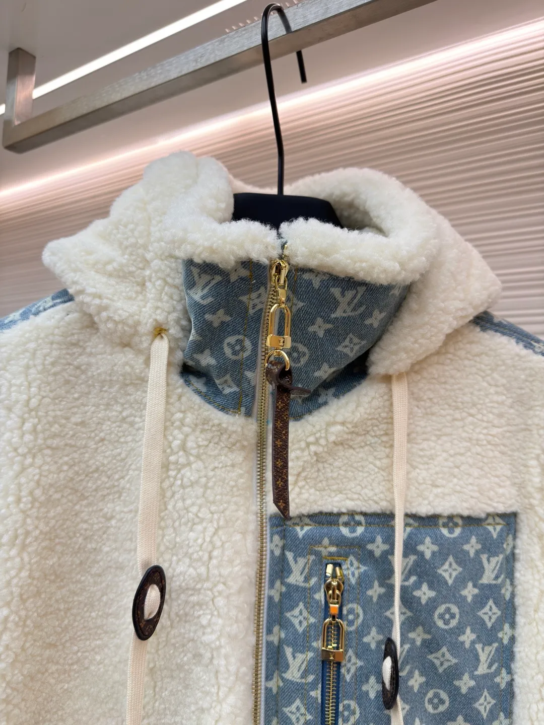 LOUIS VUITTON Letter jacquard splicing lamb wool ski hooded jacket ●Original version: purchased and developed by 26909 ●Item number: 1682241-C35 ●Fabric: lamb wool fabric ●Technology: jacquard production ●Color: off-white ●Version: fitted version ●Weight: about 1245 grams ●Size: 34-36-38-40-42-44 ●Description: The main body of this lamb wool spliced denim jacket is made of imported imitation lamb wool fabric, which has been processed by carding and shaping processes. The wool feels fluffy and soft and is not easy to shed and pill. The fabric has a uniform weight and has both warmth retention and breathability. The neckline, placket and chest pockets are spliced ​​with classic presbyopic denim. The denim is enzymatically washed to create a natural aged texture. The presbyopic pattern is embossed, making the texture three-dimensional and not easy to fall off. The body adopts a loose hooded fit, with a built-in shaping lining on the brim and an adjustable drawstring design; a custom metal zipper is used at the placket, and the chain teeth are gold-plated for smooth pulling and anti-oxidation. The edges of the pockets are reinforced with double stitching, and the splicing of lambswool and denim is made by hand caulking. The stitching is fine and smooth. Every detail is strictly controlled, showing the craftsmanship and quality of high-end clothing. The overall wiring is straight and delicate, the fabric is comfortable and soft, and the color is consistent without color difference. It can be matched with the same style to create a fashionable look and control various occasions. Customized accessories, complete with three standards, same style for men and women!